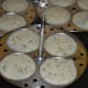 Step seven: Steam-cook them for 12 minutes on high-heat. Turn off the heat. Take out the idli stand. Separate the idlis from the stand once they are warm.