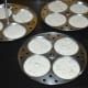 Step six: Pour about 3 tablespoons of the batter into each greased idli moulds. Arrange the stand, keep inside the cooker or steamer.