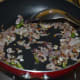 Step three: In the same pan, throw in mustard seeds. Let them splutter. Add finely chopped onions and slit green chilies. Saute them until onions turn translucent.