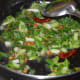 Step two: Throw in chopped spring onions. Add some salt. Stir-cook on a high heat for 3 minutes.