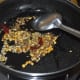 Step one: Make a tempering with oil, cumin seeds, mustard seeds, split chickpeas, white lentils, and broken dry red chilies, as per instructions.