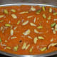 Spread chopped pistachios and almonds on it. Press them in a little so that they stick firmly. Set aside to cool.
