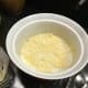 Sprinkle Parmesan cheese into the souffle dish.