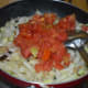 Step four: Throw in tomatoes. Stir-cook till tomatoes get mashed.