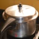 Step three: Cover the cooker. Place the weight. Let it whistle two times. Turn off the heat.