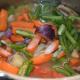 Step five: Add chopped veggies to the cooker. Add some salt. Throw in slit green chilies. Stir well.