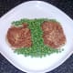 Peas are plated around potato cakes