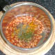 Additional seasonings are added to baked beans in tomato sauce
