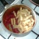 Fusilli pasta is added to tomato sauce