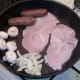 Sausages, bacon, mushrooms and onion are fried together