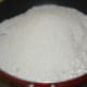 Step two: Add grated coconut, sugar, and water in a deep bottomed pan. Set the heat to medium-low.