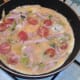 Egg is poured over sprouts and bacon combination