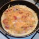 Cheese is scattered over set tortilla