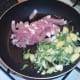 Chopped bacon and shredded sprouts are added to hot frying pan