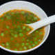 Step nine: Pour this soup equally into four bowls. Add equal amount of cooked green peas to each bowl. Garnish this soup with freshly chopped green coriander leaves.