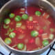 Stock is added to soup pot and ingredients are stirred together