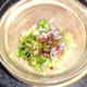 Prepared salad ingredients are added to a mixing bowl