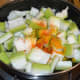 Step two: Put bottle gourd cubes in a deep-bottomed pan or sauce pan. Add some water. Throw in turmeric powder, red chili powder, and salt. Mix well.