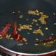 Step one: Heat ghee or oil in a deep-bottomed pan. Throw in cumin seeds. Let them crackle. Add broken dry red chilies. Saute for five seconds.