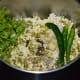 Step two: Strain the water. Collect it in a bowl. Use it for grinding. Put mung beans, moong dal, and rice to a mixer or grinder. Add ginger, green chilies, salt, cloves, and fresh coriander.