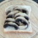 Fried garlic mushrooms are arranged on a slice of bread