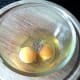 Eggs are broken in to a small bowl and seasoned