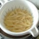 Penne pasta is drained and allowed to steam