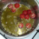 Halved tomatoes are added to garlic oil