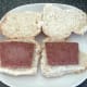 Sliced sausages are laid on bread rolls