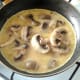Beaten eggs are poured over mushrooms