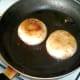 Mushroom cups are turned in frying pan
