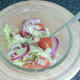 Salad ingredients are stirred through seasoned oil