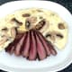 Sliced ostrich steak is plated
