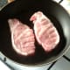 Pork fillets are seasoned and added to frying pan