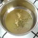 Garlic and herbs are added to oil in saucepan