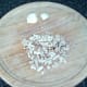 Mushroom stems are moderately finely chopped and garlic cloves are peeled