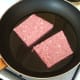 Sliced sausages are added to hot frying pan