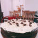 Decorating the cake with chocolate chips and biscoff cookies.