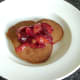 Cooled stewed plums are spooned on to pancakes