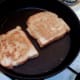 Eggy bread is turned in frying pan