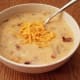 When finished, mash the potatoes in your soup with a potato masher. Then drop in your cream cheese and shredded cheese and stir until melted. Top with more cheese, bacon and chives if you'd like.