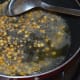 Step two: Heat oil in a deep-bottomed pan. Add mustard seeds. Let them crackle. Throw in split chickpea and white lentils. Saute over low fire until the lentils become golden brown.