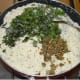 Step four: Add the ground mixture of ginger-pepper-green chilies. Also add chopped curry leaves and chopped coriander leaves. Continue sauteing for another 2 minutes.