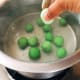 Bring water in a deep pan to a boil. Lower the balls in slowly, one at a time, and leave them in the rolling boil.