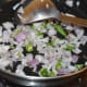 Step two: Add chopped onions and slit green chilies. Continue the sauteing until onions turn pinkish.