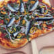 Russia takes fish on pizza to a new level with mockba, a style of pizza that uses mackerel, tuna, sardines, and salmon, along with a heaping helping of onions.