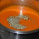Step five: Add the paste to the pan or vessel containing the liquid. Mix well. Add dry herbs like basil and oregano. Add milk. Add some salt, if needed. Give the mixture a nice boil. Simmer for 2 minutes. Turn off the heat.