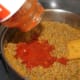 Adding pasta sauce.