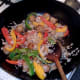 Soy sauce is added to fried rice in wok just before serving
