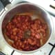 Dried herbs are added to beans in saucepan